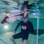 Swim instructor gives lessons to a young boy