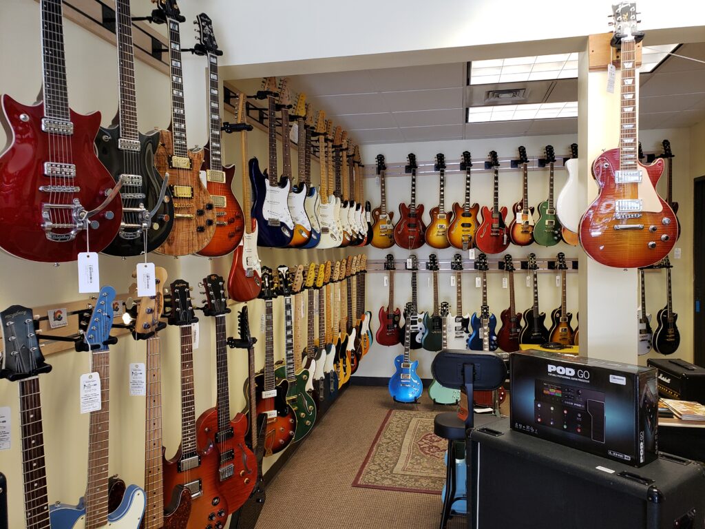 Many guitars handing on walls