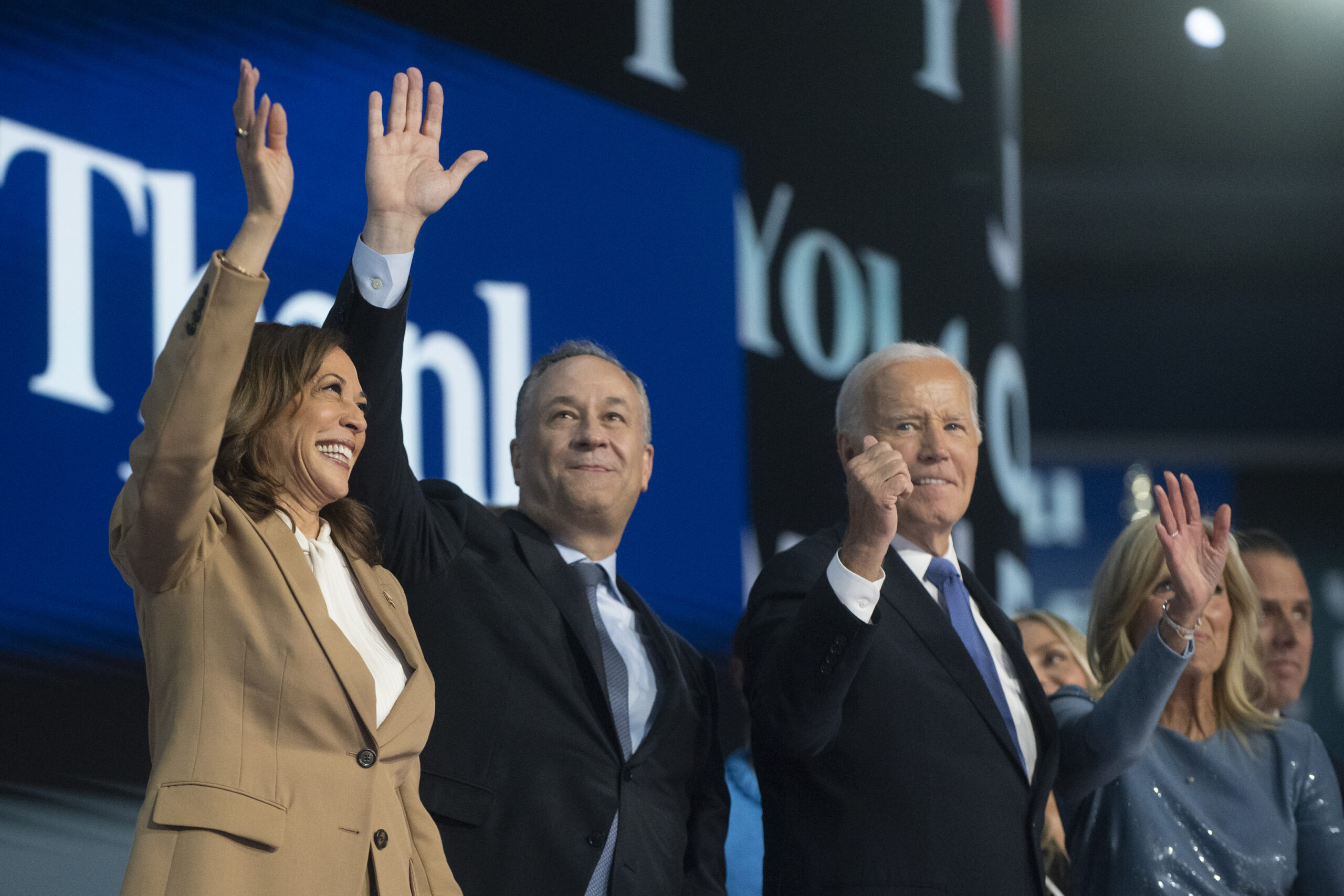 Kamala Harris, Tim Walz, and Joe Biden wave to crowd on stage at the 2024 National Democratic Convention. 